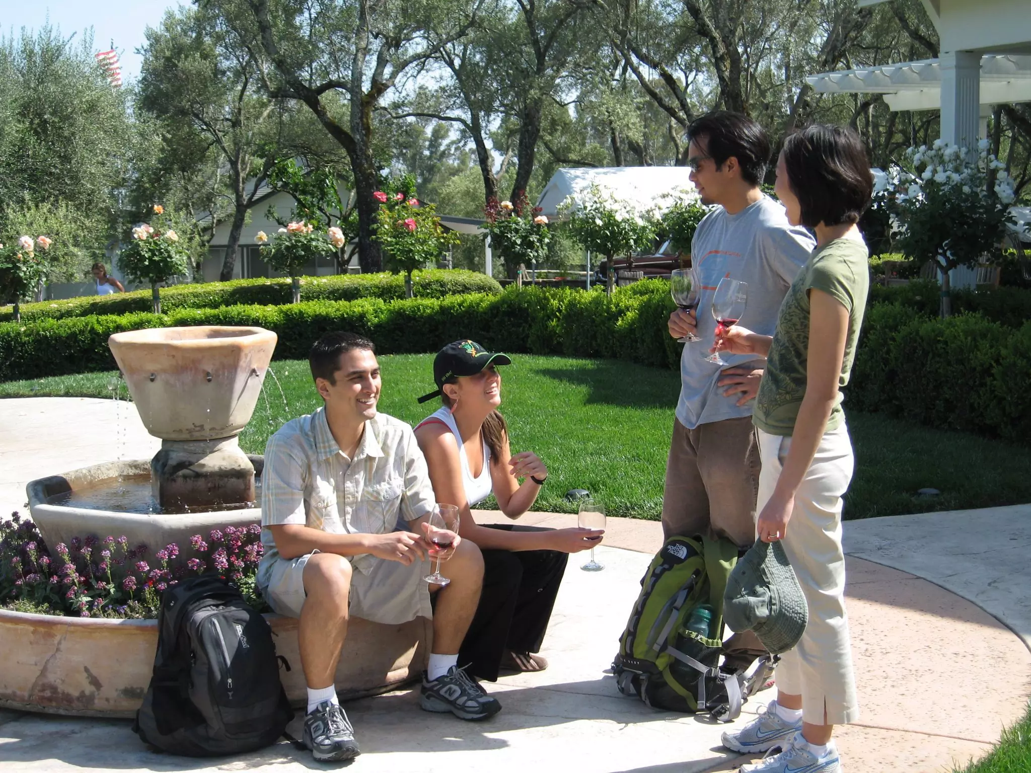 Group of people taste wine surrounding fountain